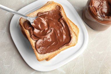 Masaya tost üzerine tatlı çikolata krem yayma, üst görünüm
