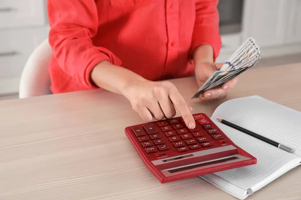 Vrouwen tellen geld met rekenmachine aan tafel, close-up — Stockfoto