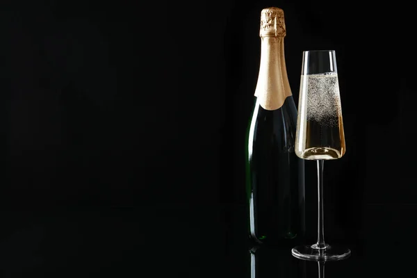Bouteille et coupe de champagne sur fond noir, espace texte — Photo