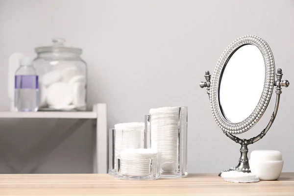 Bavlněné podložky, zrcadlo a krém na stole v koupelně, prostor pro text — Stock fotografie