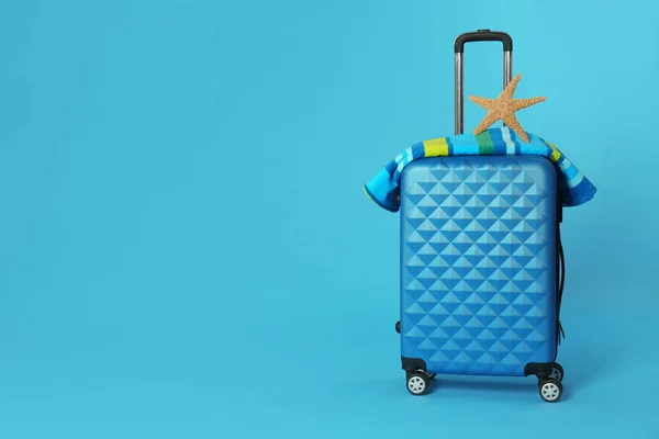 Elegante maleta con toalla y estrella de mar sobre fondo de color. Espacio para texto — Foto de Stock