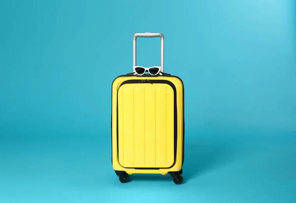 Snygg res väska med sol glasögon på färg bakgrund — Stockfoto