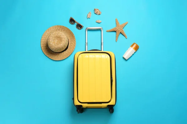 Composizione flat lay con valigia e articoli da spiaggia su sfondo colore — Foto Stock