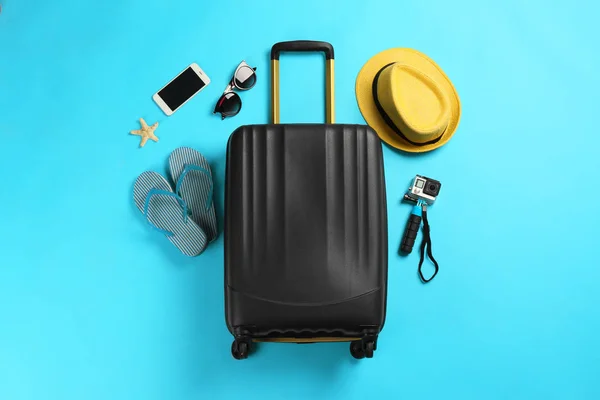 Flat lay composition with suitcase and traveler's accessories on color background — Stock Photo, Image