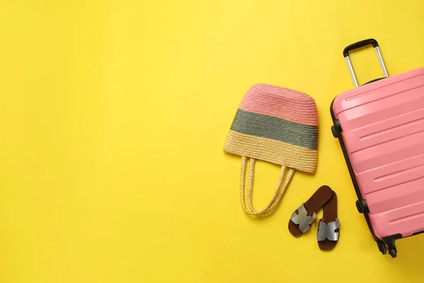 Elegante maleta, bolso de playa y zapatos en color de fondo, vista superior. Espacio para texto — Foto de Stock
