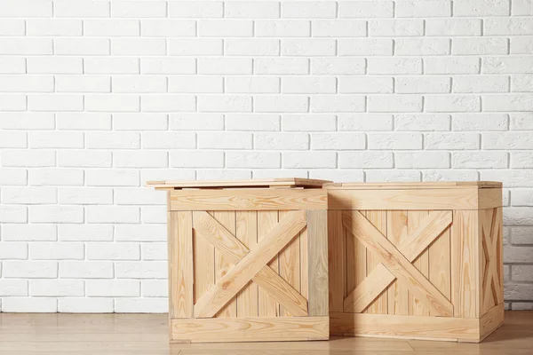 Wooden crates on floor near brick wall, space for text — Stockfoto
