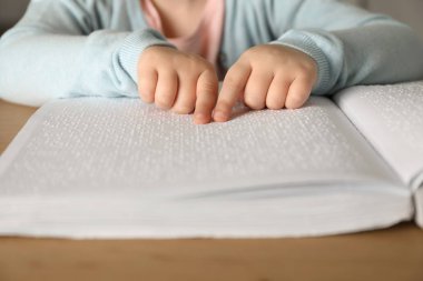 Parmaklık masada Braille yazılmış kör çocuk okuma kitabı, çekim