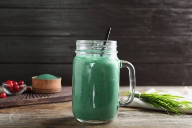 Ahşap masada Spirulina Smoothie ve Buğday çim ile Mason kavanoz