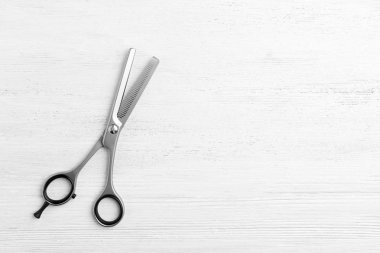 Beyaz ahşap arka planda metin için inceltme makas ve boşluk, üst görünüm. Kuaför aracı