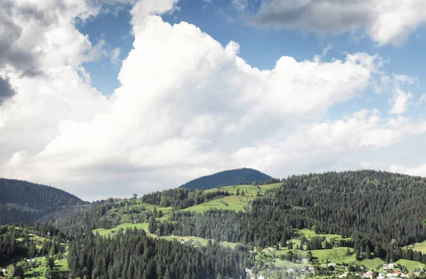 Vista pitoresca da aldeia e da floresta nas encostas das montanhas — Fotografia de Stock