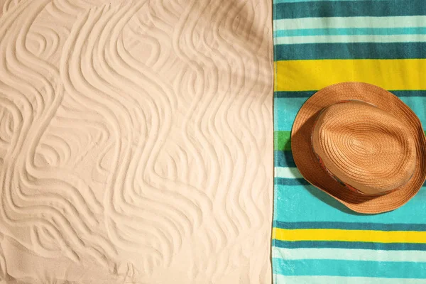 Brillante toalla y sombrero sobre arena, vista superior con espacio para texto. Objetos de playa — Foto de Stock