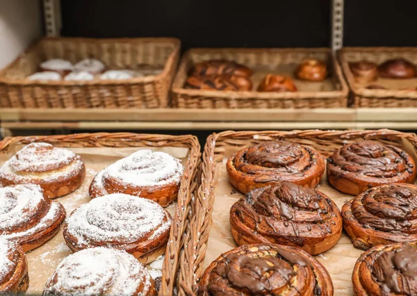 Rieten bakjes met verschillende zoete broodjes in bakkerij — Stockfoto