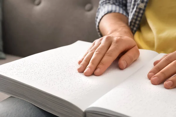 Blind Man lezen boek geschreven in braille op sofa, close-up — Stockfoto