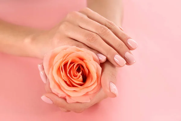 Vista de cerca de la mujer con rosa sobre fondo de color. Tratamiento de spa — Foto de Stock