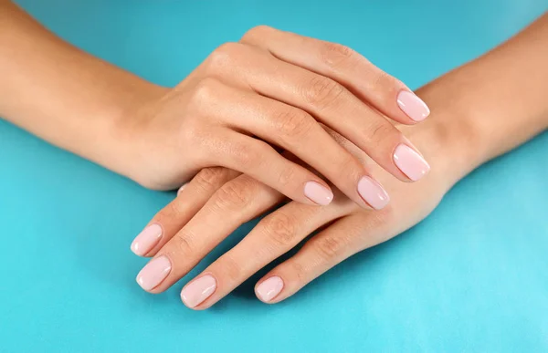 Vista de cerca de la mujer con hermosas manos en el fondo de color. Tratamiento de spa — Foto de Stock