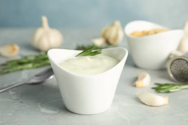 Samenstelling met kom knoflooksaus op grijze tafel — Stockfoto