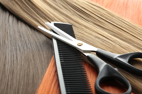 Thinning scissors and comb on hair, closeup. Hairdresser service — Stock Photo, Image