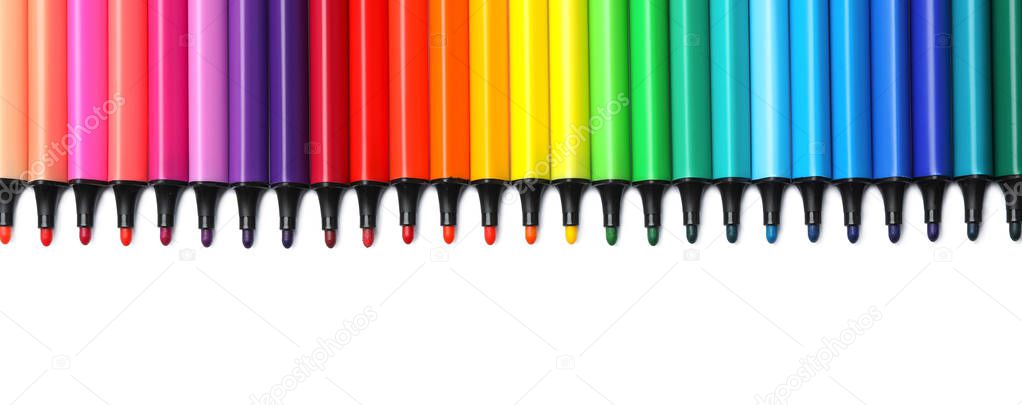 Many colorful markers on white background, top view. Rainbow palette