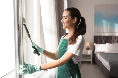 Yatak odasında paspas ile profesyonel hizmetli Temizleme penceresi