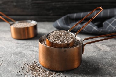 Gri masa üzerinde Chia tohumları ile saucepans