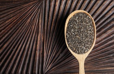 Spoon with chia seeds on wooden background, top view. Space for text clipart