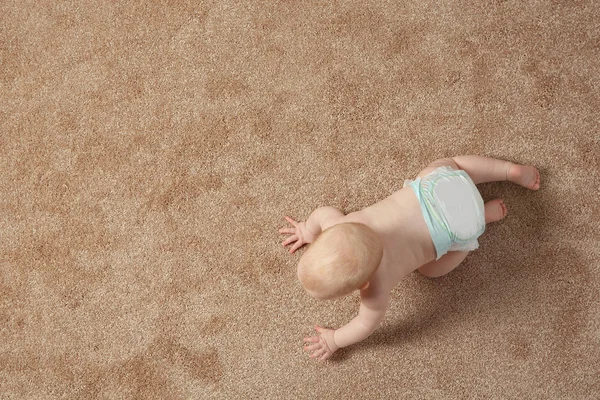 Lindo bebé arrastrándose en la alfombra en el interior, vista superior con espacio para el texto — Foto de Stock