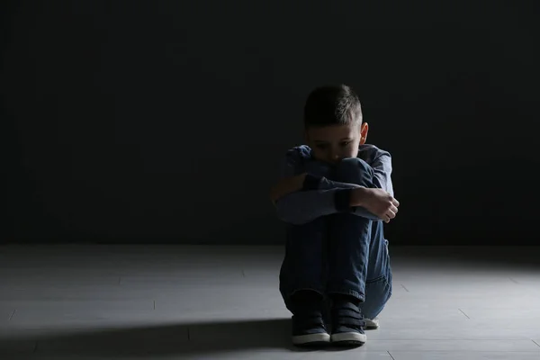Rapaz perturbado sentado no quarto escuro. Espaço para texto — Fotografia de Stock