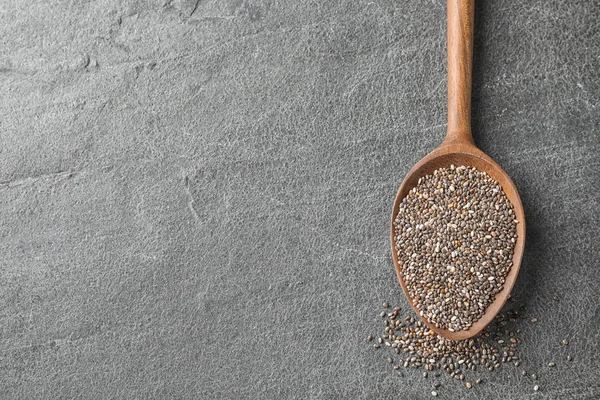 Cuchara con semillas de chía sobre fondo gris, vista superior. Espacio para texto — Foto de Stock