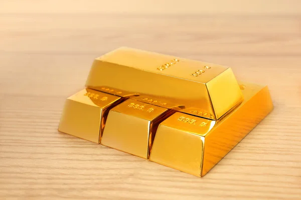 Goldglänzende Barren auf Holztisch gestapelt — Stockfoto