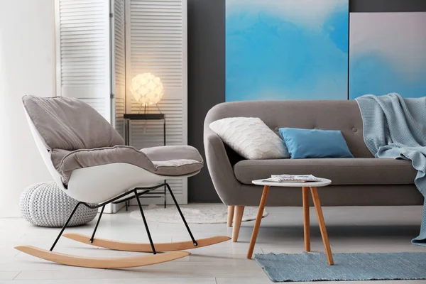 Современный интерьер гостиной с удобным диваном и креслом-качалкой — стоковое фото