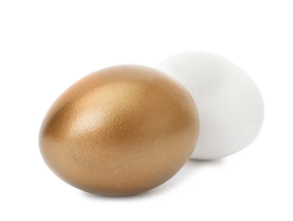 Золотое яйцо и обычное на белом фоне — стоковое фото