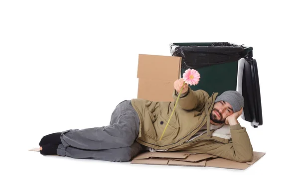 Poor homeless man with flower near trash bin isolated on white — Stock Photo, Image