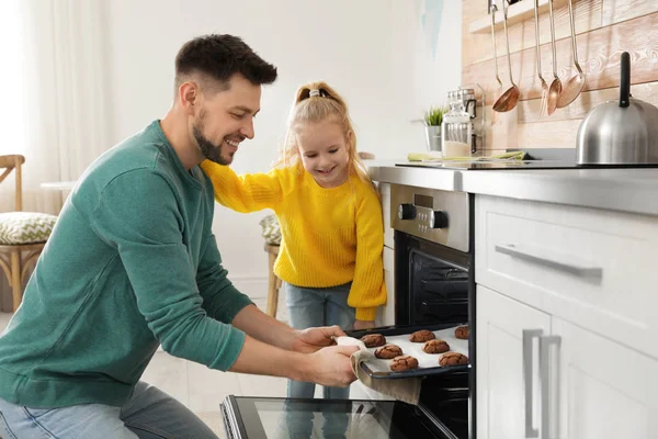 Padre con su hija horneando galletas en el horno en casa — Foto de Stock