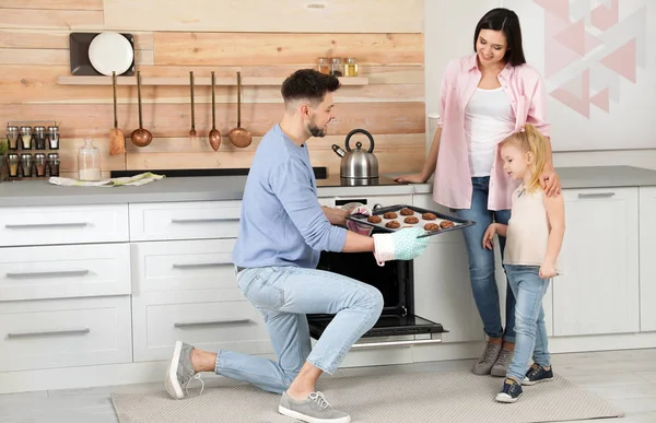 Homem tratando família com forno assado biscoitos na cozinha — Fotografia de Stock