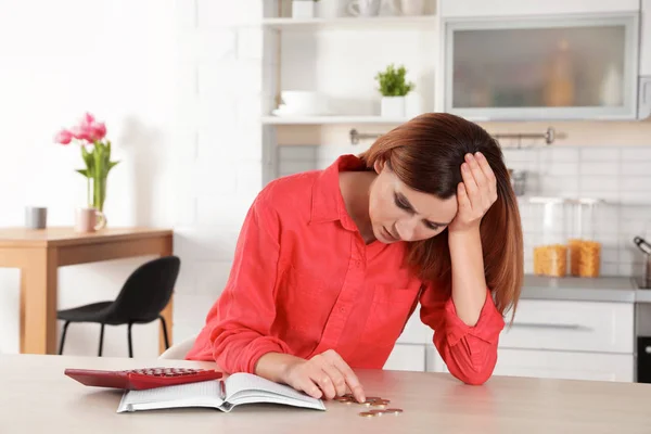 Mulher triste contando dinheiro na mesa dentro de casa — Fotografia de Stock