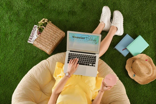 Yapay çim üzerinde seyahat Blogger sitesi ile kadın ve laptop, üst görünüm