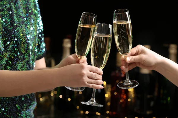 People clinking glasses of champagne on blurred background, closeup — Stock Photo, Image