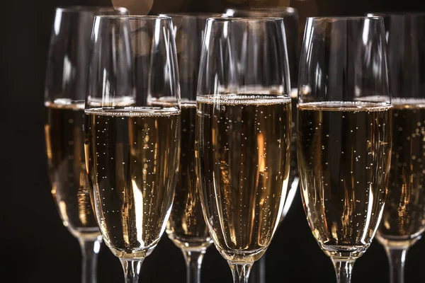 Sklenice šampaňského na tmavém pozadí, zaostřená — Stock fotografie