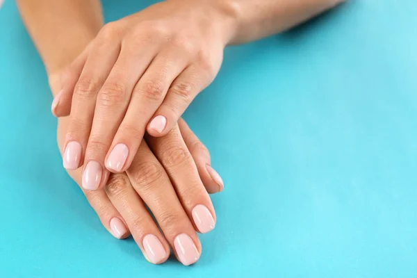 Vista de cerca de la mujer con hermosas manos en el fondo de color, espacio para el texto. Tratamiento de spa — Foto de Stock