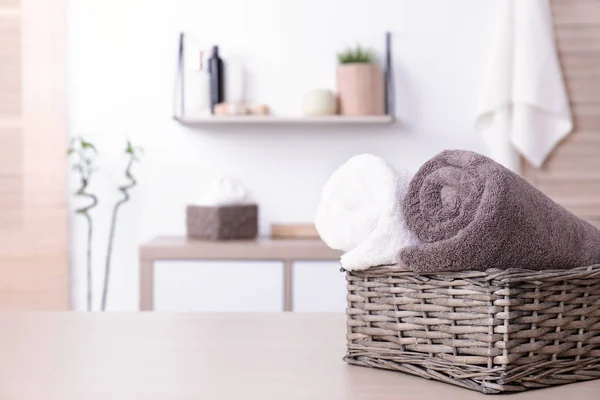 Cesta con toallas frescas enrolladas en la mesa en el baño. Espacio para texto —  Fotos de Stock