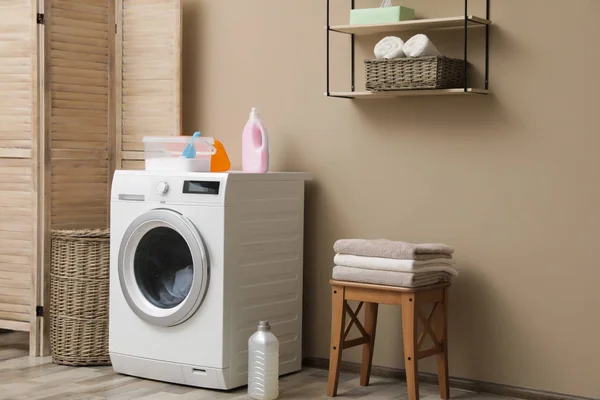 Máquina de lavar roupa moderna perto da parede de cor no interior da lavanderia. Espaço para texto — Fotografia de Stock