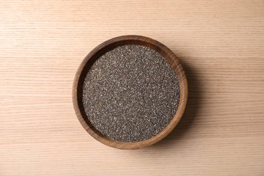 Ahşap arka planda Chia tohumları ile kase, üst görünüm