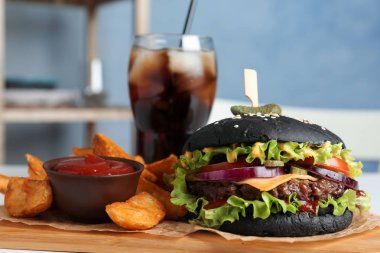 Masa üzerinde siyah Burger ve patates kızartması ile Board, çekim
