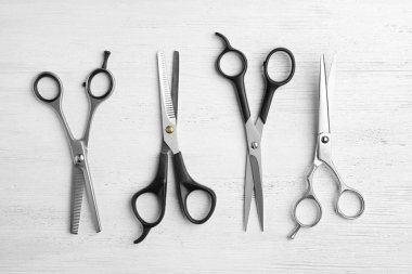 Beyaz ahşap arka planda makas ile düz yatıyordu kompozisyon. Kuaför aletleri