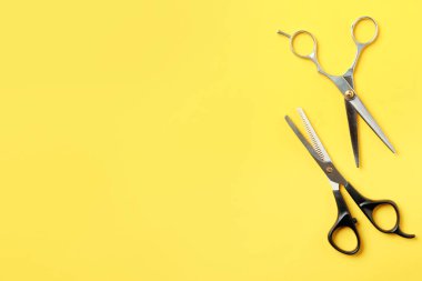 Düz renk arka planda metin için makas ve boşluk ile kompozisyon yatıyordu. Kuaför aletleri