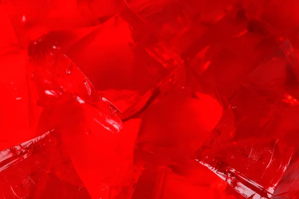 Läckra röda gelé kuber som bakgrund, närbild — Stockfoto