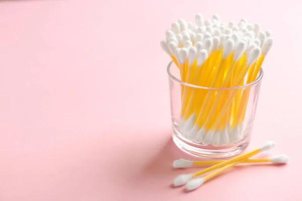 Glass with cotton swabs on color background. Space for text — Stock Photo, Image