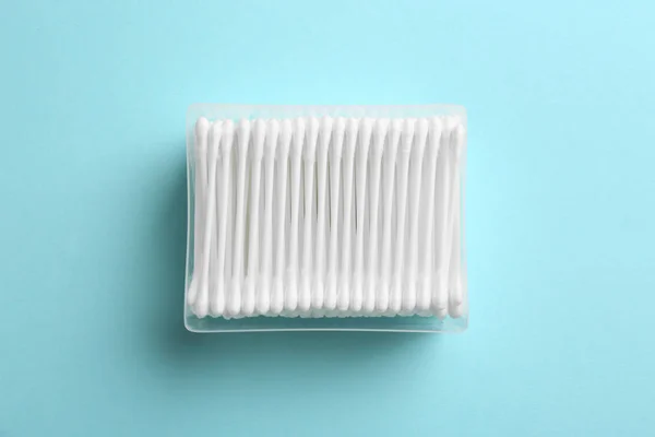 Contenitore di plastica con tamponi di cotone su sfondo colore, vista dall'alto — Foto Stock