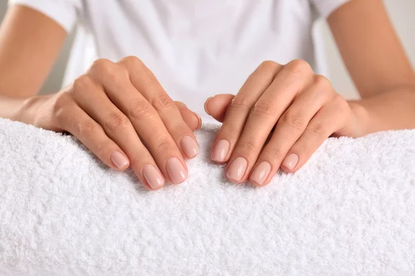 Vista de cerca de hermosas manos femeninas en la toalla. Tratamiento de spa — Foto de Stock