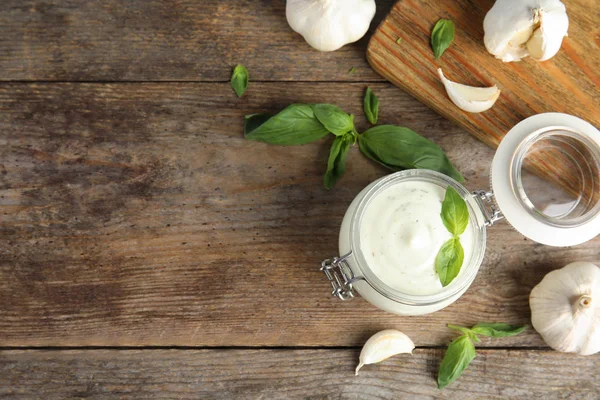 Flat lay composition with garlic sauce on wooden background. Space for text — Stock Photo, Image